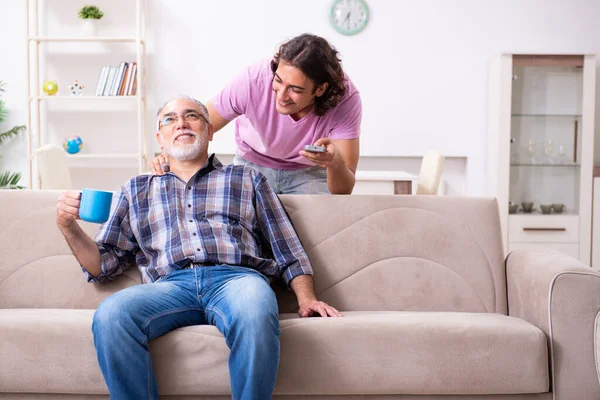 Giovane studente e il suo vecchio nonno a casa — Foto Stock