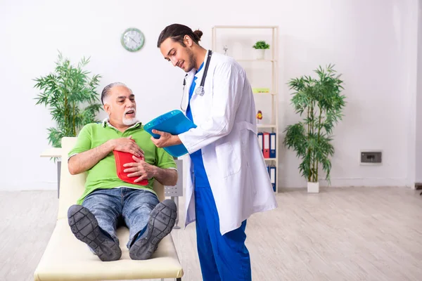 Gamle man besöker ung manlig läkare gastroenterolog — Stockfoto