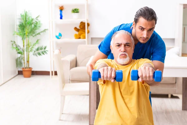 Junger Arzt besucht alte Patientin zu Hause — Stockfoto