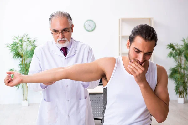 Jovem paciente do sexo masculino visitando médico experiente — Fotografia de Stock