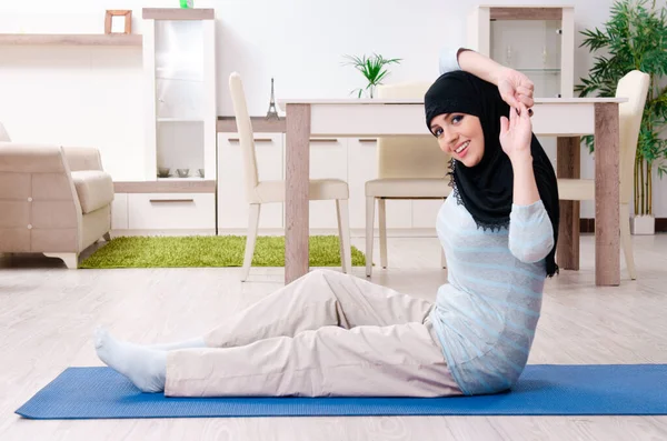 Jonge vrouw in hijab doet oefeningen thuis — Stockfoto