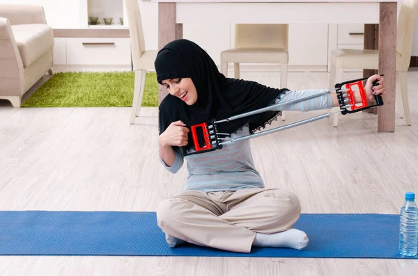 Junge Frau im Hidschab macht Übungen zu Hause — Stockfoto