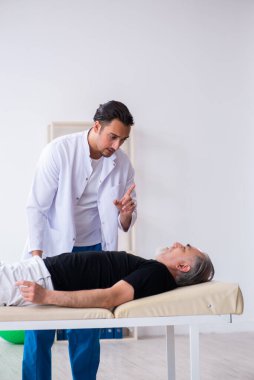 Yaşlı adam genç doktoru ziyaret ediyor.