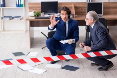 Ofiste çalışan iki kriminolog.