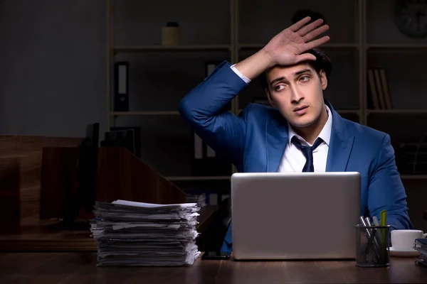Ung manlig anställd som arbetar natt på kontoret — Stockfoto