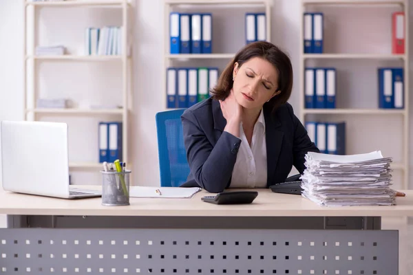 Middle-aged female employee suffering in the office