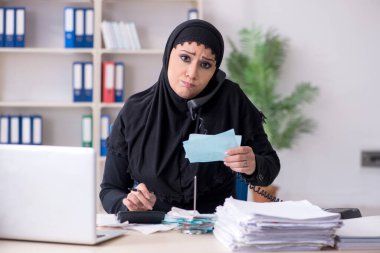 Ofiste çalışan tesettürlü kadın muhasebeci.