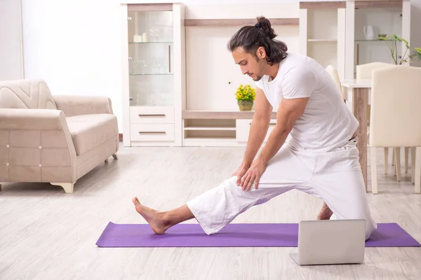 Young man doing physical exercises at home