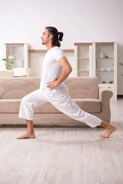 Young man doing physical exercises at home