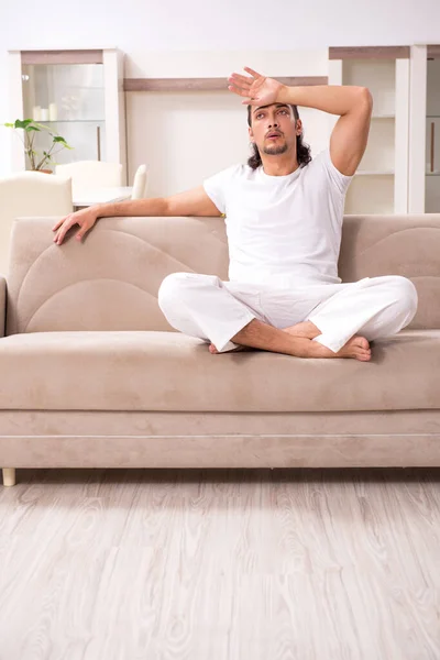 Jovem fazendo exercícios físicos em casa — Fotografia de Stock