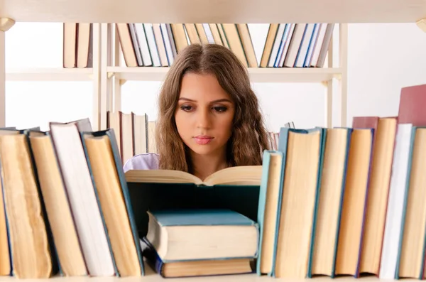 Fiatal női hallgató készül vizsgákra a könyvtárban — Stock Fotó
