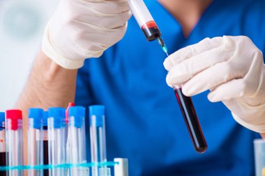 Genç laboratuvar asistanı hastanede kan örneklerini test ediyor