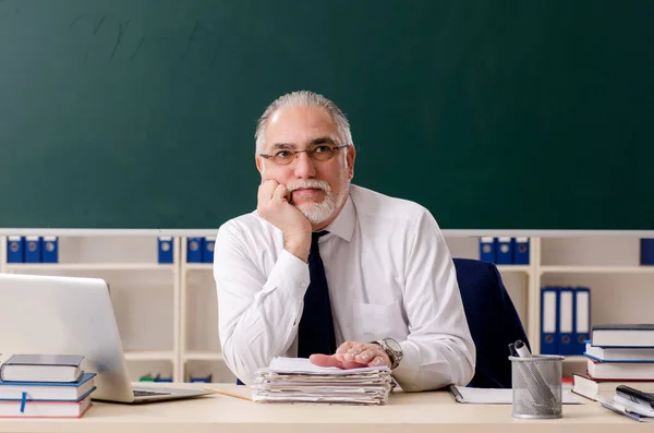 Leeftijd mannelijke leraar in de voorkant van schoolbord — Stockfoto