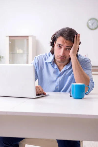 Jonge mannelijke werknemer die thuis werkt — Stockfoto