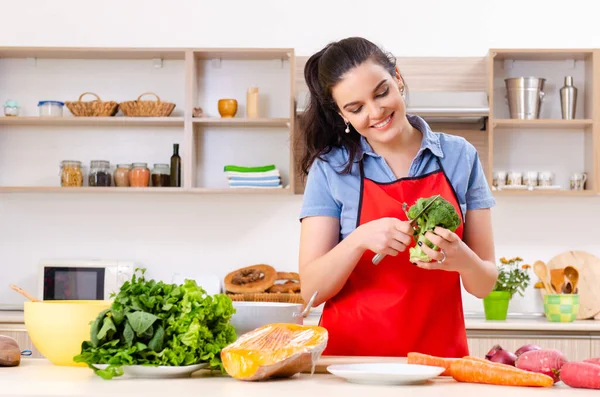 Jonge vrouw met groenten in de keuken — Stockfoto