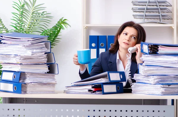Zakenvrouw van middelbare leeftijd ongelukkig met buitensporig werk — Stockfoto