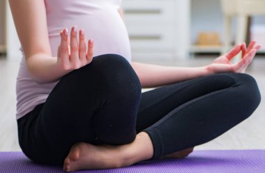 Hamile kadın çocuk doğurma beklentisiyle egzersiz yapıyor.