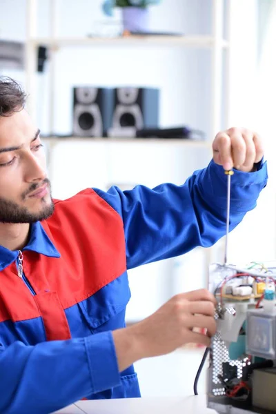 Young repairman fixing and repairing microwave oven — Stock Photo, Image