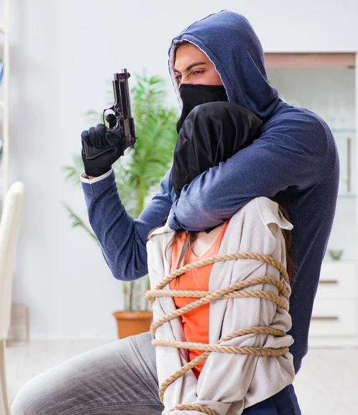 Homme armé agressant une jeune femme à la maison — Photo
