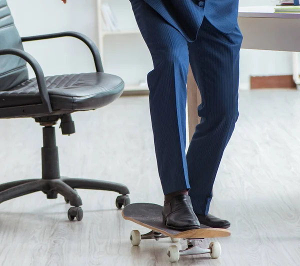 Ung affärsman med skridsko på kontoret i sport koncept — Stockfoto