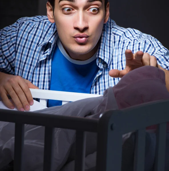 Gelukkig vader kijken na pasgeboren baby 's nachts — Stockfoto