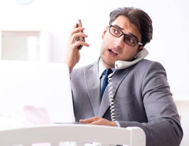 Genç işadamı yeni doğduktan sonra evde çalışmaya çalışıyor.