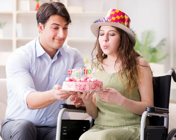 Joven familia celebrando cumpleaños con persona discapacitada —  Fotos de Stock