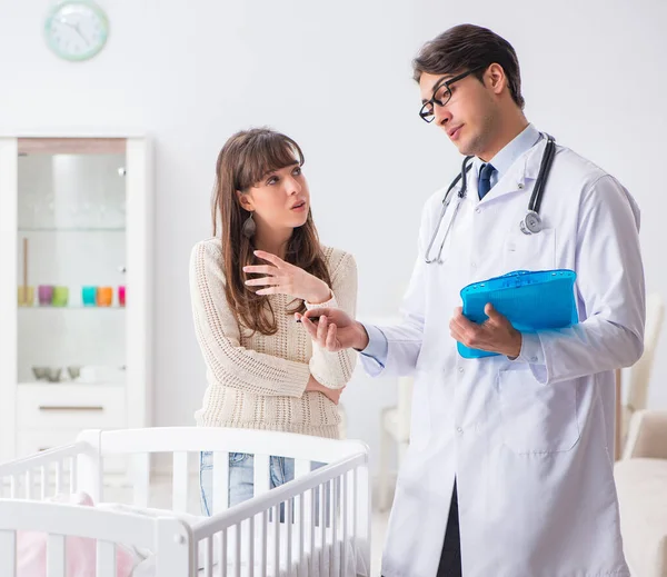 Doctor explaining to young mother — Stock Photo, Image