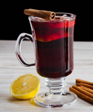 Haşlanmış şarap, yılbaşı masasında servis edilen bardaklarda parlıyor.