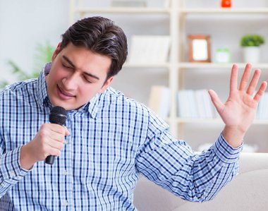 Evde karaoke yapan komik adam.