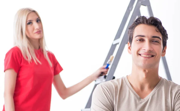 Família jovem fazendo trabalho de pintura durante a renovação da casa — Fotografia de Stock