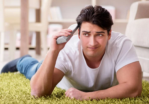 Mann schaut zu Hause auf dem Fußboden fern — Stockfoto