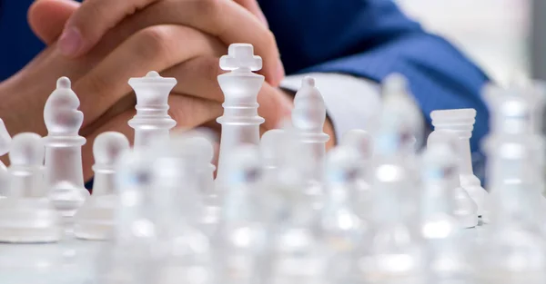 Young businessman playing glass chess in office — Stock Photo, Image