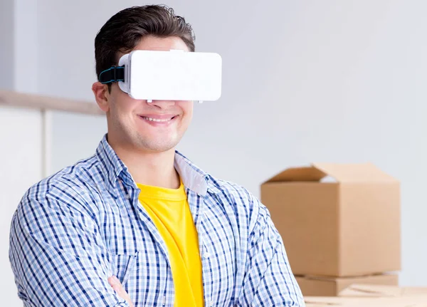 Young man wearing VR glasses moving in new apartment — Stock Photo, Image