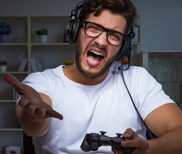 Jovem jogando jogos longas horas atrasado no escritório — Fotografia de Stock