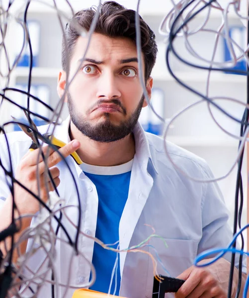 Elektrik teknisyeni tamir konseptinde kabloları çözmeye çalışıyor. — Stok fotoğraf