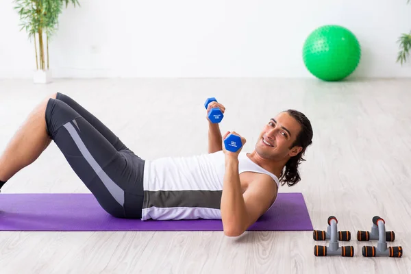 Young handsome man doing sport exercises indoors — Stock Photo, Image