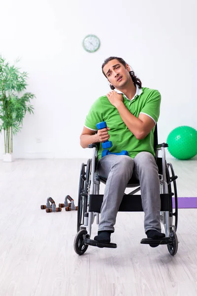 Joven en silla de ruedas haciendo ejercicios en interiores — Foto de Stock