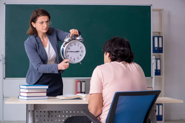 Gammal kvinnlig lärare och manlig student i klassrummet — Stockfoto