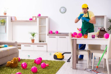 Genç erkek müteahhit partiden sonra ev işi yapıyor.