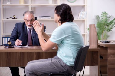 Genç adam deneyimli erkek avukatı ziyaret ediyor.