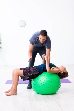 Genç baba ve oğlu egzersiz yapıyor.