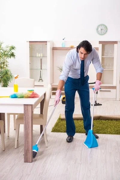 Jovem empresário limpando a casa — Fotografia de Stock