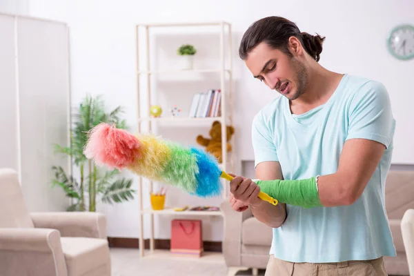 Jonge gewonde man die het huis schoonmaakt — Stockfoto