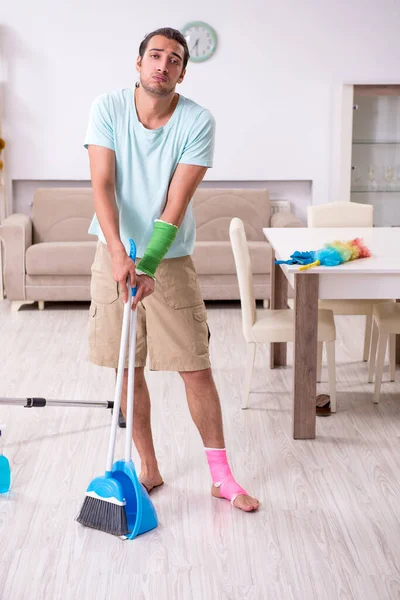 Fiatal sérült férfi takarítja a házat. — Stock Fotó