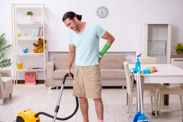 Jeune homme blessé nettoyer la maison — Photo