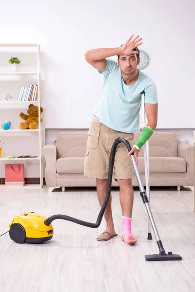Genç yaralı adam evi temizliyor. — Stok fotoğraf