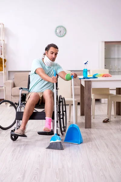 Jongeman in rolstoel maakt het huis schoon — Stockfoto