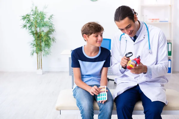 Jovem médico examinando menino na clínica — Fotografia de Stock