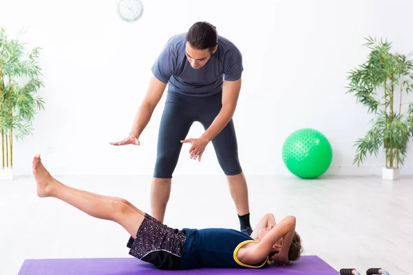 Jovem pai e seu filho fazendo exercícios — Fotografia de Stock